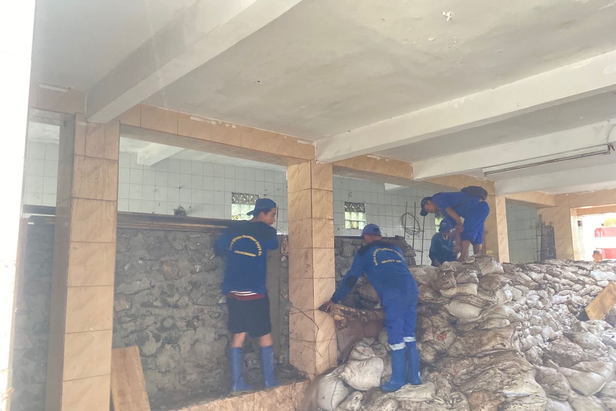 Pasukan Biru Sigap Hadapi Hujan Deras dengan Susun Karung Pasir di Mushala Jati Padang